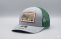 Gray and green cap with embroidered color patch on a gray hat background